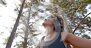 A young biracial woman with curly hair smiles outdoors