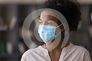 Young biracial woman in facemask look in distance