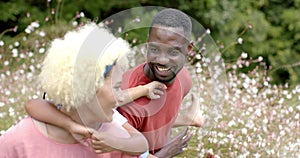 A young biracial woman with family enjoys a playful moment outdoors at home