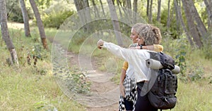 Young biracial woman points something out to her friend during a hike, with copy space