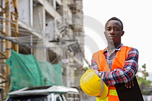 Young black African man construction worker holding clipboard an