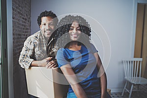 Young black african man and his girlfriend moving boxes into new house together and making a beautiful life.Cheerful
