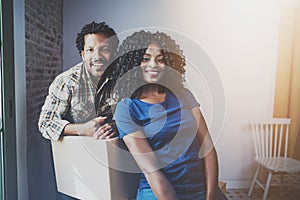 Young black african man and his girlfriend moving boxes into new house together and making a beautiful life.Cheerful