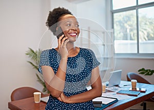 Young Black business woman talks on cellphone in boardroom smiling