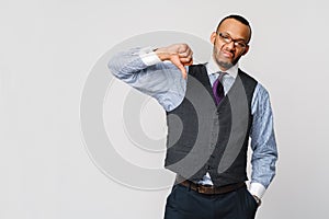 Young black businessman with a dissenting serious dislike expression with thumbs down in disapproval