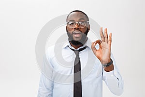 Young black businessman having happy look, smiling, gesturing, showing OK sign. African male showing OK-gesture with his
