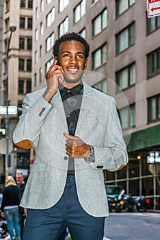 Young black businessman talking on cell phone on street in New York City