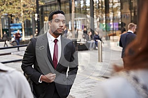 Young black businessman walking in a street in the city, selective focus