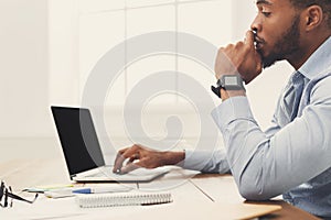 Young black businessman working with laptop