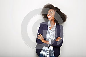 Young black businesswoman laughing against gray wall