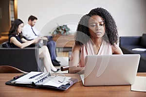 Young black businesswoman using laptop at a desk photo