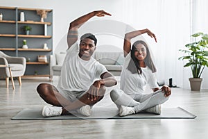 Young black couple doing side bend exercise together