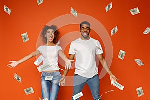 Young black couple enjoying money banknotes shower