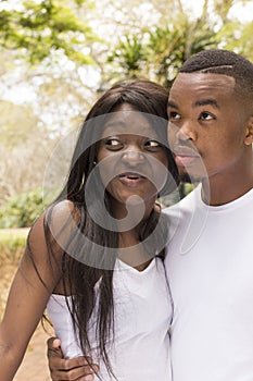 Young Black couple loving embrace at park