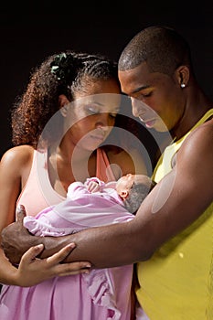 Young black couple lovingly holding their newborn baby