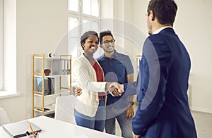 Happy black couple meeting and shaking hands with realtor, loan broker or insurance advisor