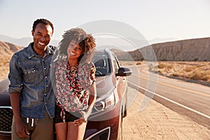 Young black couple standing on desert roadside by their car