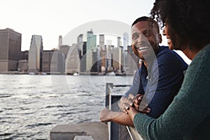 Young black couple standing on quayside, side view