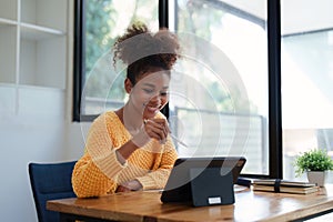 Young black curly hair american african woman using digital tablet