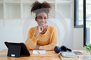 Young black curly hair american african woman using digital tablet