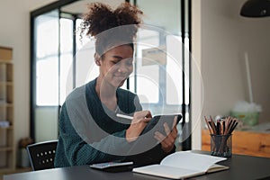 Young black curly hair American African woman using digital tablet