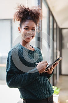 Young black curly hair American African woman using digital tablet