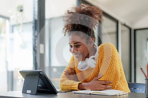 Young black curly hair American African woman using digital tablet