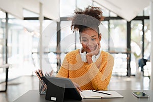 Young black curly hair American African woman using digital tablet