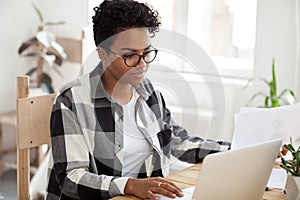 Young black employee typing on computer working in office room