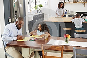 Young black family busy in their kitchen, elevated view