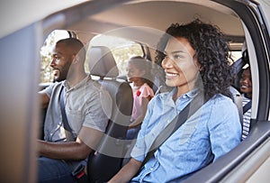 Young black family with children in a car going on road trip photo