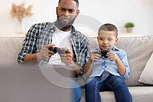 Young Black Father And Little Son Playing Videogames At Home
