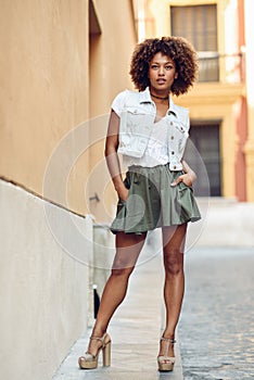 Young black girl, afro hairstyle, standing in urban background