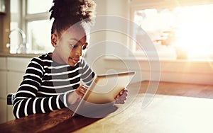 Young black girl browsing on a tablet-pc