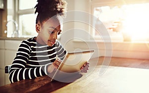 Young black girl browsing on a tablet-pc photo