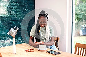 Young black girl drinking her coffee at cafe.