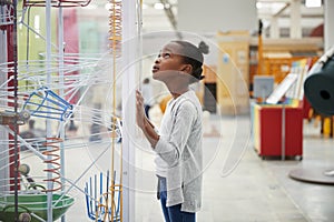 Young black girl looking at a science exhibit, close up photo