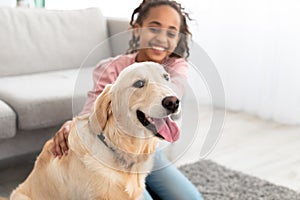 Young black girl playing with dog, selective focus on pet