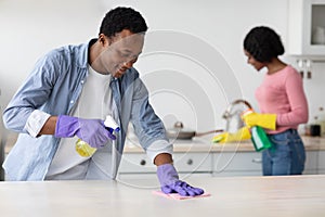 Young black guy and lady cleaning their new house
