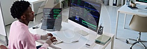 Young Black Man Coding Software on Computer and Laptop in Office