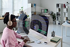 Young Black Man Coding Software on Computer in Office Workspace