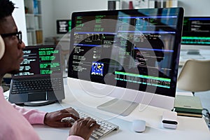Young Black Man Coding Software on Desktop Computer in Office