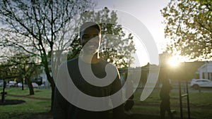 Young black man exhaling while taking a break during sunset in park