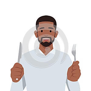 Young black man holding knife and fork. Hungry man waiting for food