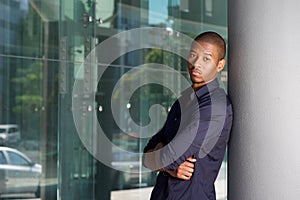 Young black man leaning against wall in city