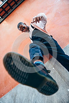 Young black man man kicking towards the ground