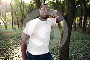 A young black man in park. Outdoor portrait of traveler. Portrait of a young african man outdoors. Outdoors portrait concept