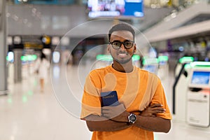 Young black man ready to travel at airport terminal waiting for flight
