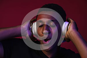 Young black man singing while listening music with headphones
