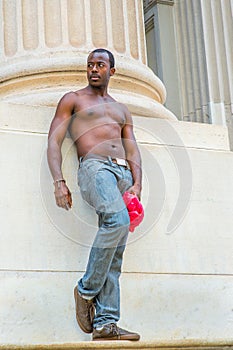 Young black man standing outsides in New York City in hot summer, relaxing